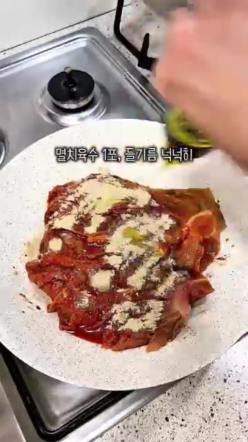 팬에 묵은지를 넣고 고춧가루, 설탕, 들기름을 넣어 버무린다. — 들기름김치찜 레시피 (고기 없이 밥도둑)