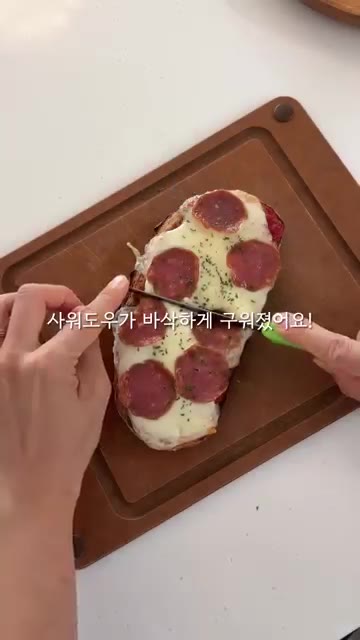 구워진 피자 위에 파슬리 가루를 뿌린다. — 사워도우 살라미 피자 만들기
