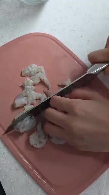 껍질을 벗기고 내장을 제거한 새우를 칼로 잘게 다진다. — 새우매생이전 만들기