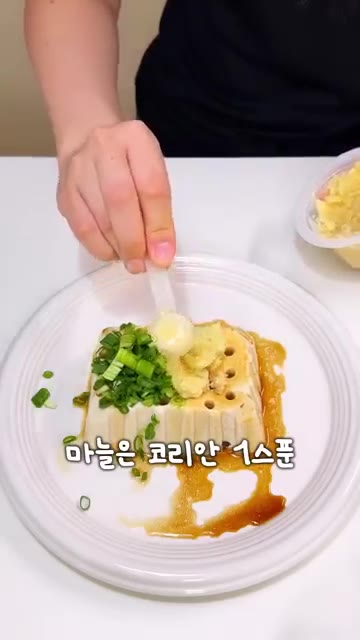 연두부 위에 양념장을 붓고 쪽파, 다진 마늘, 고춧가루를 올린다. — 2700만 조회수 두부 요리, 진짜 맛있을까?