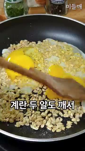 구워진 오트밀 위에 계란 2개를 깨뜨려 넣고 소금, 통깨, 검은깨를… — 바쁠 때 무조건 이거! 오트밀에 계란 톡 까넣고 5분 만에 끝내는 아침메뉴 (원팬토스트)